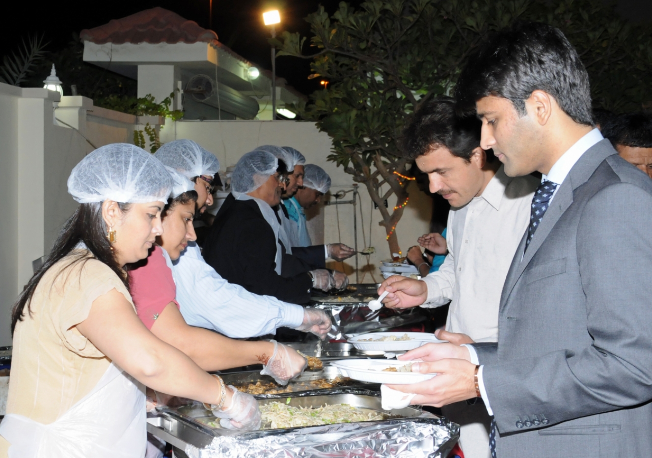 Volunteers serving dinner to the Jamat qho had gathered in Doha.