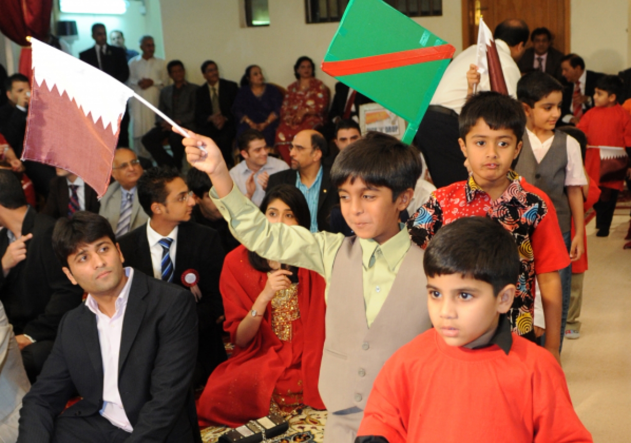 Children parade into the hall waving the Qatari and Ismaili flags.