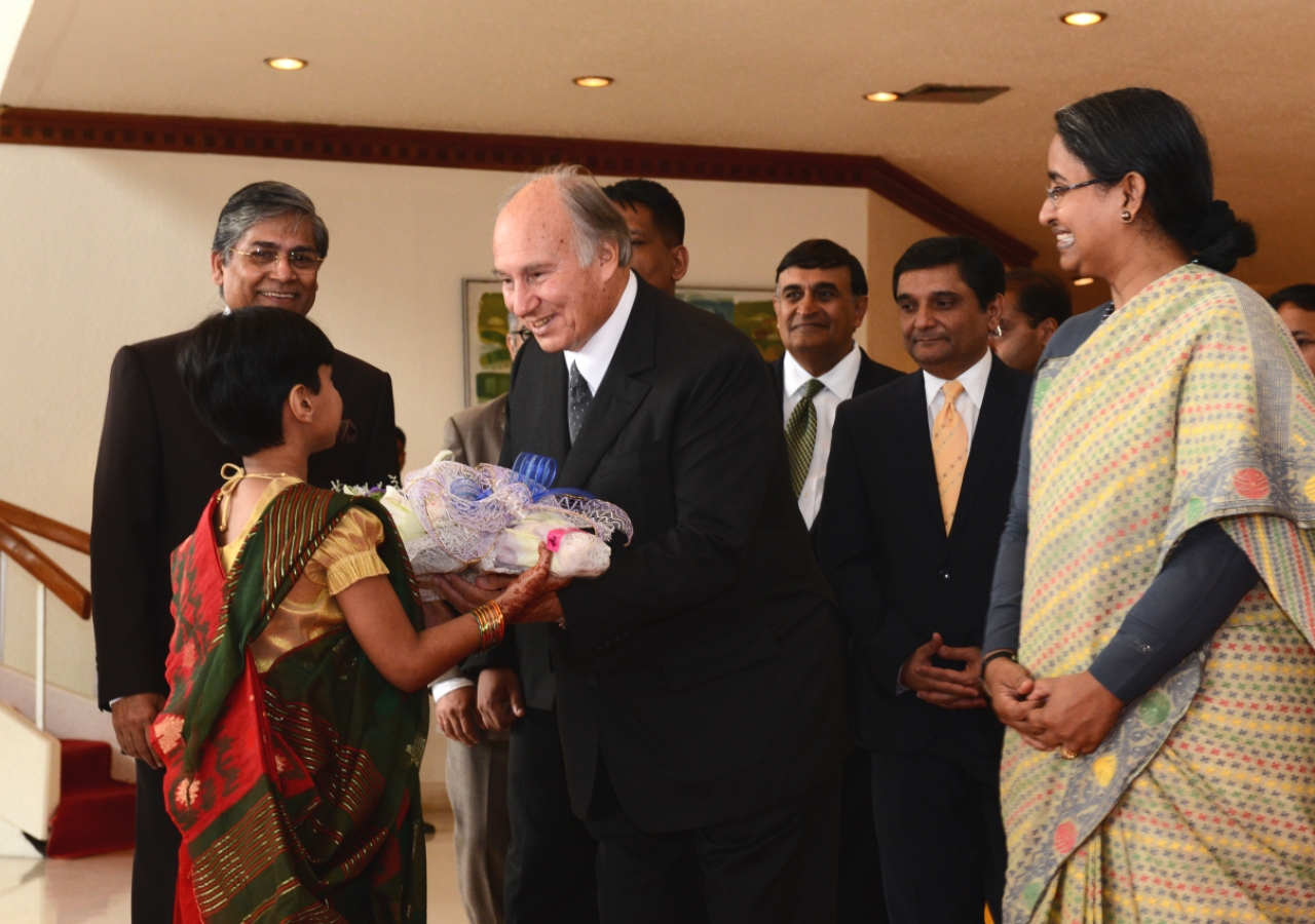 As the Foreign Minister and Ambassador at Large look on, a young girl presents Mawlana Hazar Imam with flowers on behalf of the Government of Bangladesh prior to his departure.