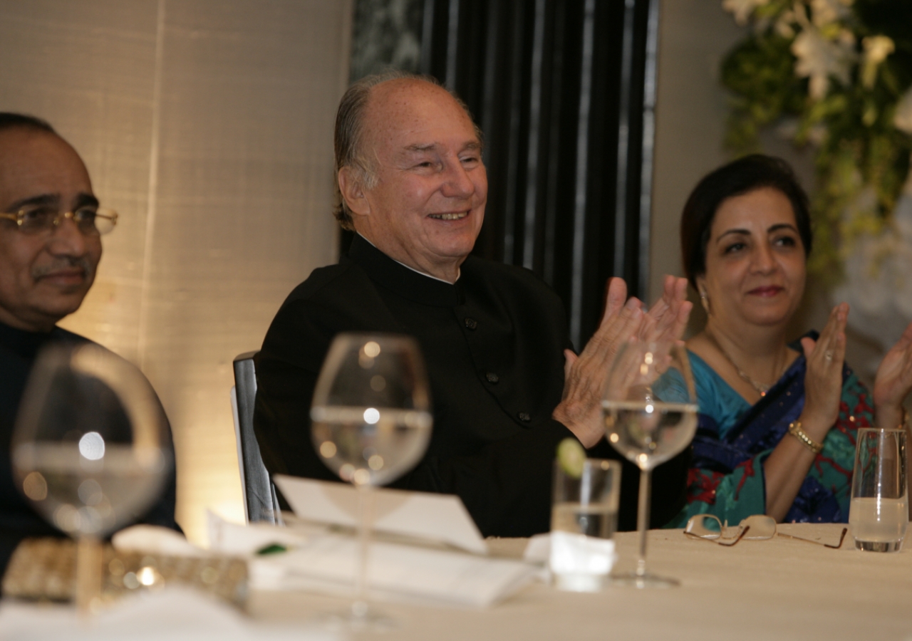 Mawlana Hazar Imam, joined by Ismaili Council President Aitmadi Gulam Rahimtoola and President Banoo Samira Rahimtoola, applauds the musical performance at the Jamati institutional banquet.