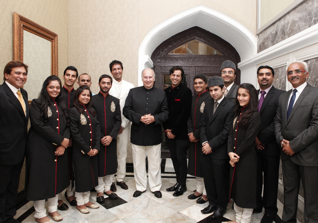 Mawlana Hazar Imam poses for a photograph with the performers at the conclusion of the institutional dinner.