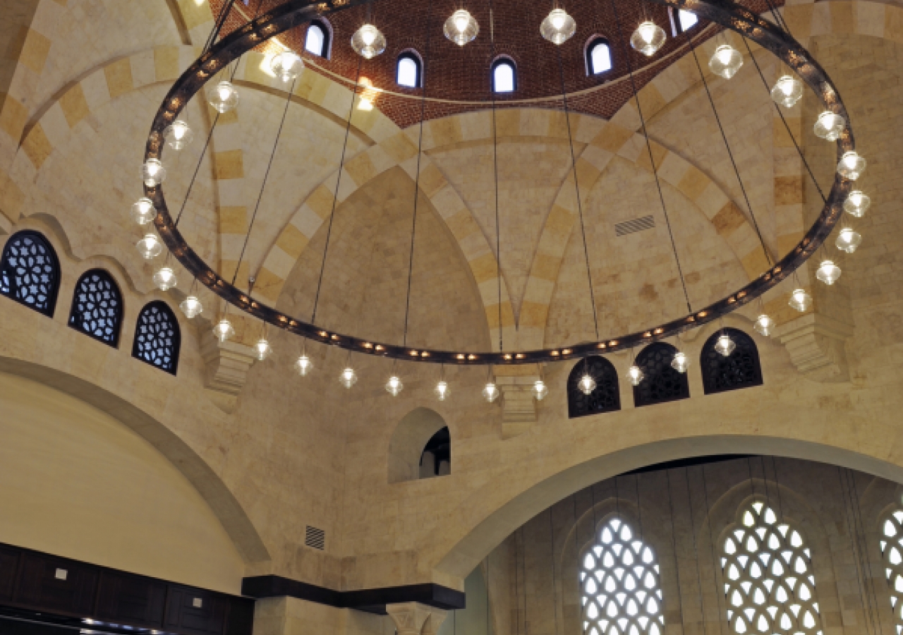 The congregational hall of the Ismaili Centre, Dubai features the building's largest dome. Its octagonal shape is supported by meticulously engineered heavy corbels, which dominate the space. The ambience is set by the enormous brass chandelier from Egypt