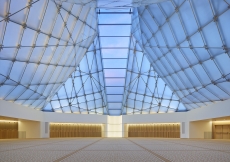 Inside the Jamatkhana, the central skylight panel descends to a white translucent onyx block. Shai Gil