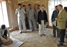 Mawlana Hazar Imam observes as a local craftsman demonstrastes restoration techniques. 