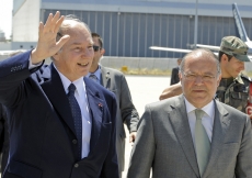 Mawlana Hazar Imam waves to the leaders of the Jamat gathered at the airport to welcome him, as Alberto Costa, Minister of Justice, looks on.  