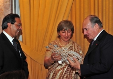 Chairman of ITREB Portugal, Parveeza Sacoor, presents a gift to Mawlana Hazar Imam as President Amirali Bhanji looks on. 