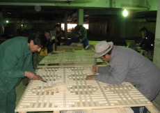 April 2009: Local craftsmen work on the latticed wood panels.