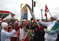 Vice-President Malik Talib passes on the flame after his run.