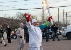 Ismaili Council for Canada President Mohamed Manji waves to the crowd, as he carries the Olympic torch on behalf of Ismailis across the country.