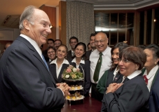 Mawlana Hazar Imam stops to speak with volunteers at a tea party for Prince Charles&amp;rsquo; visit commemorating the 25th anniversary of the Ismaili Centre, London.