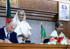 Mawlana Hazar Imam signs a protocol agreement with Foreign Minister Dr Dipu Moni between AKDN and the Government of Bangladesh, as Prime Minister Sheikh Hasina looks on.