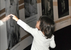 A young visitor delights in a photograph of Mawlana Hazar Imam as a baby.