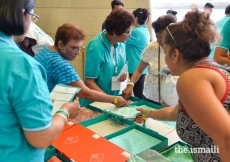 Memorabilia volunteers help Jamati members with finding a Diamond Jubilee shawl.