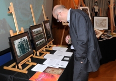 A visitor examines albums and portraits on display as part of the &quot;Across Time and Space&quot; exhibition. Riaz Kassam