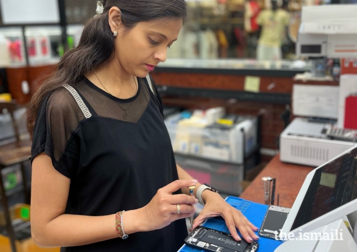 After taking a cell phone repair class, Malika Lirani now work at a repair shop in order to supplement her income.