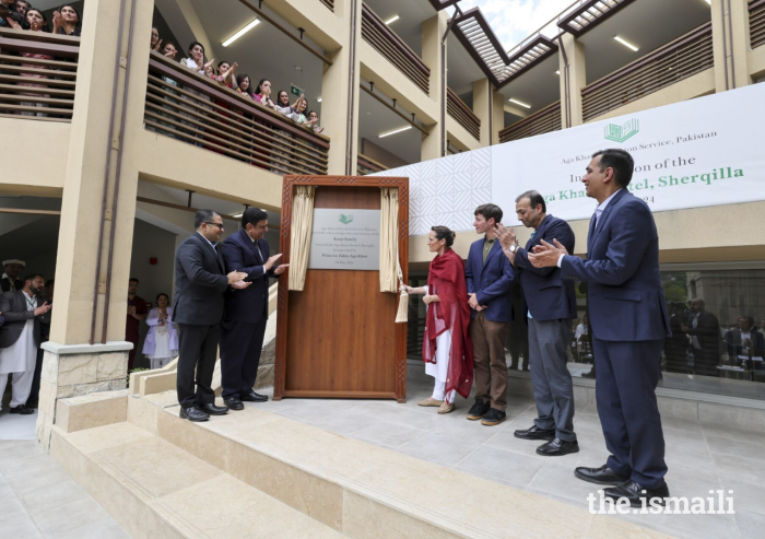 Princess Zahra, her son Iliyan, and guests reveal a plaque to commemorate the official opening of the Aga Khan Hostel in Sherqilla.