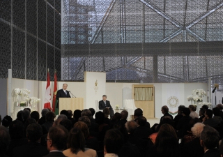 Mawlana Hazar Imam, speaking at the opening ceremony of The Delegation of the Ismaili Imamat, situated on Sussex Drive in Ottawa. Looking on, in the glass-domed atrium adorned with Jali screen is the Right Honourable Stephen Harper, PM of Canada