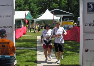 Rozina Issani and her guide Kate cross the finish line at the third annual Joe’s Team Triathlon in Muskoka, Ontario.