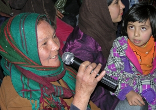 At the Kabul International Women’s Day event organised by the Ismaili Council for Afghanistan, an audience member asks a question, as a young girl looks on.