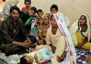 A family finds shelter from the flood devastation at a FOCUS relief camp in Sindh.