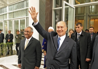 As he departs the Dushanbe Serena Hotel, Mawlana Hazar Imam waves at members of the Jamat gathered across the street.