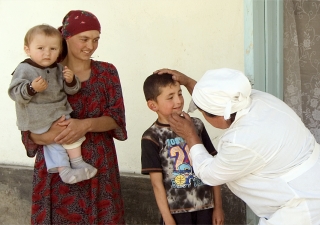 A child receives a check-up at an AKHS medical point managed by a midwife and two nurses in Shidz, Gorno-Badakhshan Autonomous Oblast.