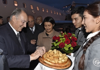 Mawlana Hazar Imam is presented with a traditional offering of non (bread) by two students from the Aga Khan School in Osh. Gary Otte