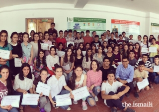 Students from grades eight and ten join Aziz Batada, and TKN volunteers Ashna Suchak and Kais Khimji for a group photograph.