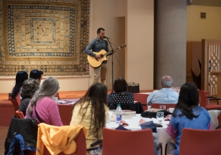 Etienne Siew performs a song on acoustic guitar.