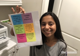 Nabeela Talib displays an example of the product of her computer code, which sends messages from her phone to her printer to print sticky notes.