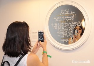 An International Art Gallery attendee snaps a photo of one of the pieces of art on display.