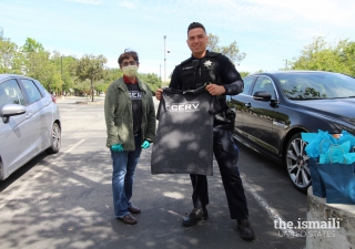 A Milpitas Police officer receives an I-CERV t-shirt from an Ismaili volunteer.