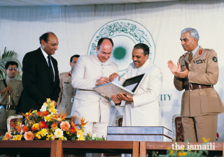 Mawlana Hazar Imam accepts the AKU Charter in 1983 as President Shamsh Kassim-Lakha looks on.