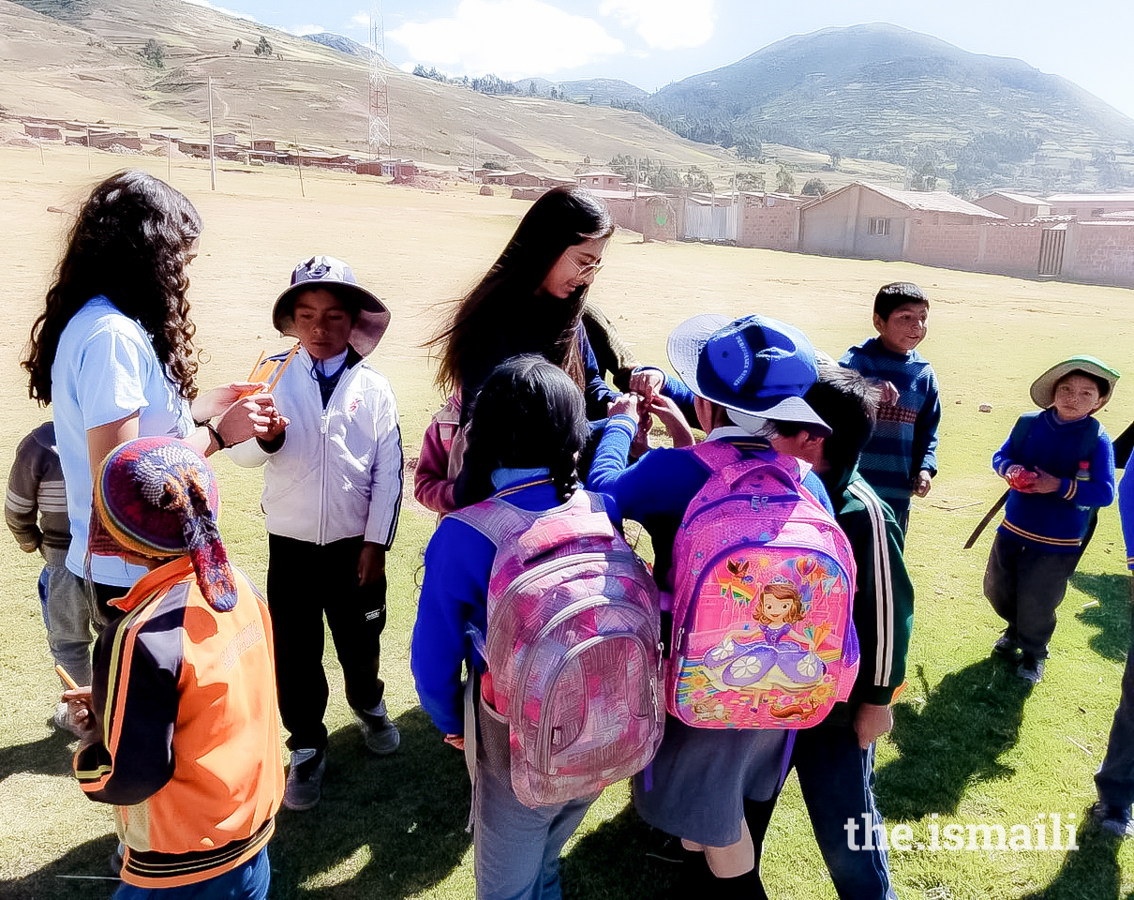 Insha and her sister, Sheza, distributing school supplies to students in Peru.