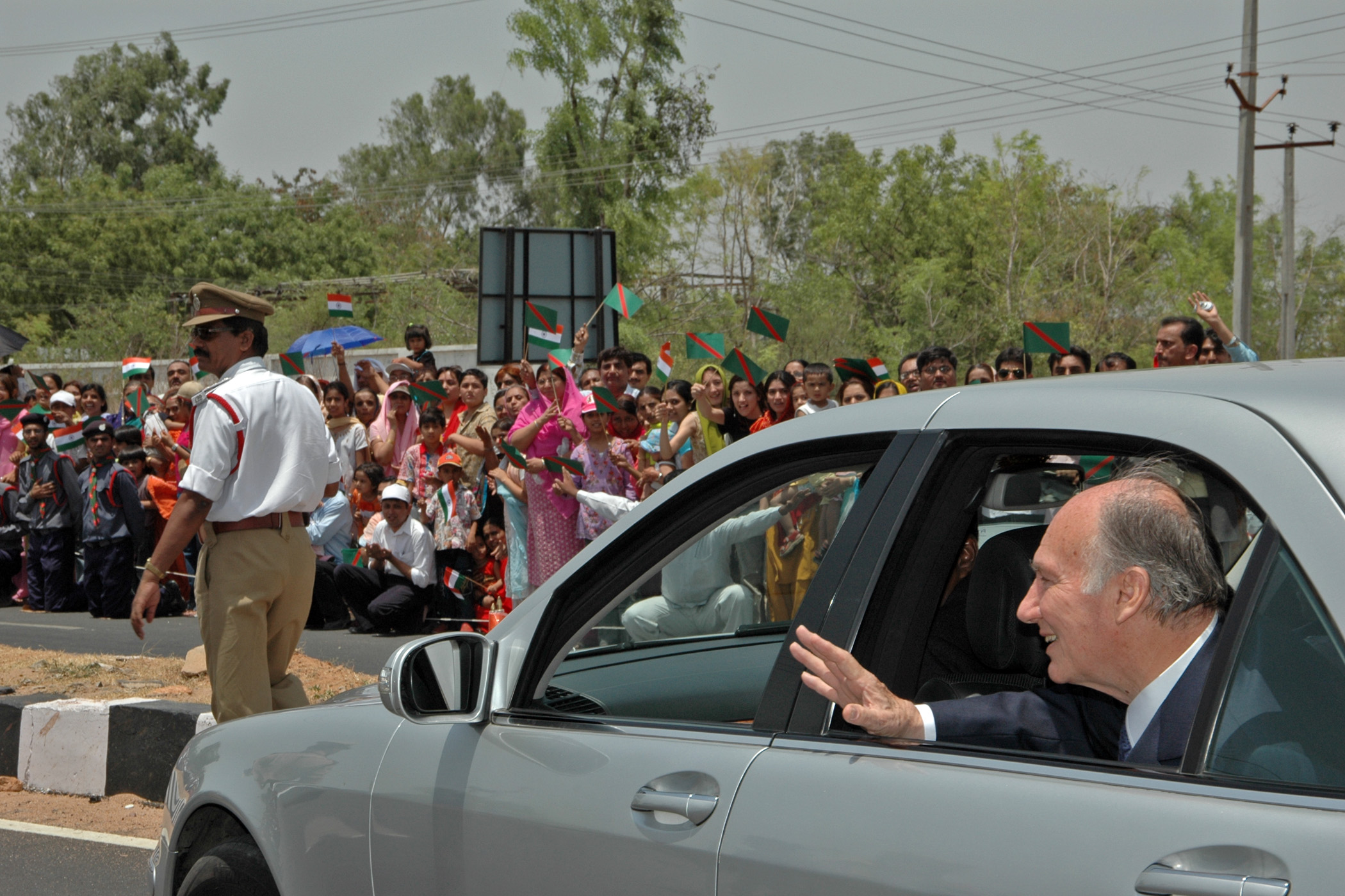 Mawlana Hazar Imam waves at members of the Jamat who lined the streets around Hyderabad airport to welcome him. Photo: Hussain Jiwan