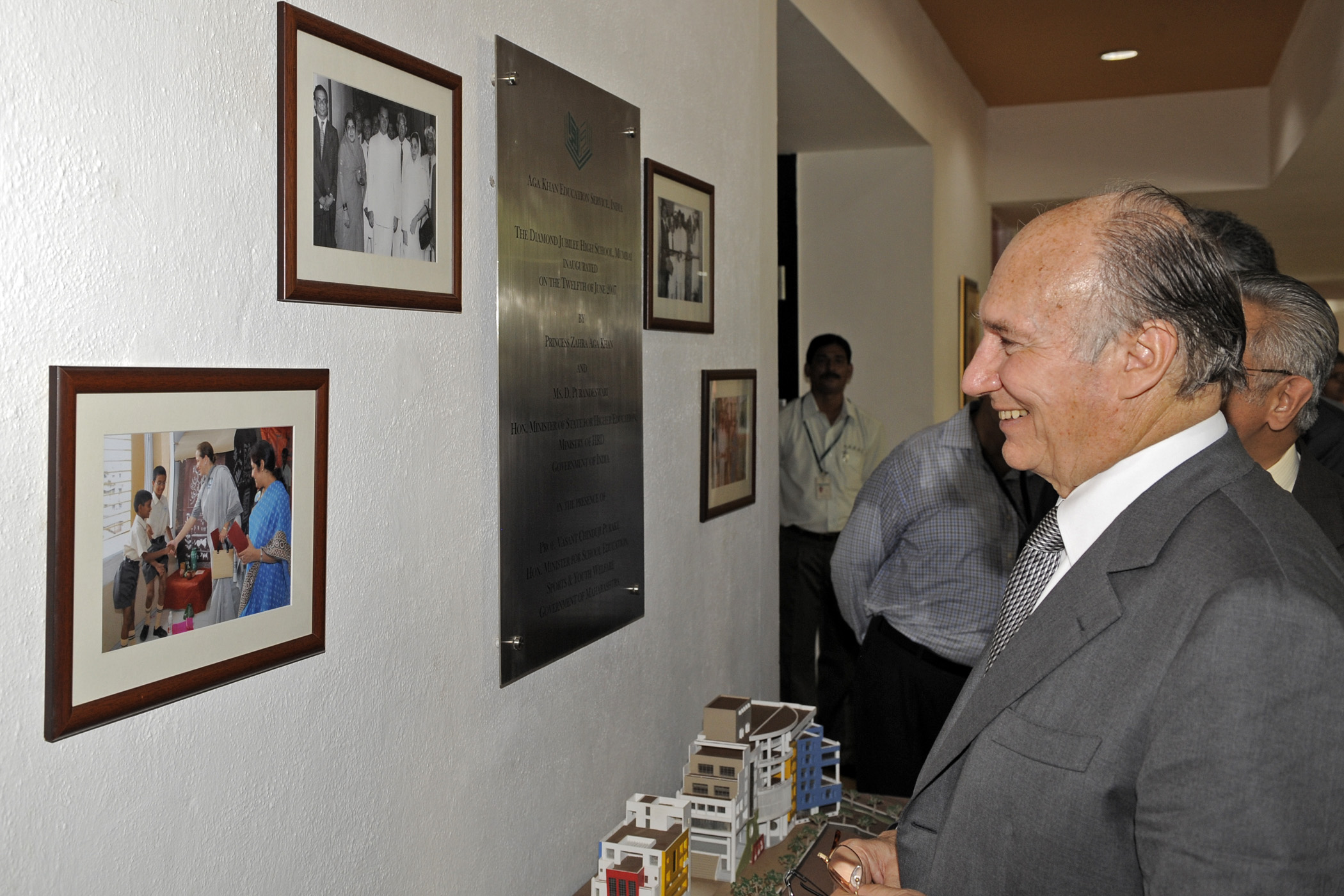 Mawlana Hazar Imam smiles as he looks at photographs of his visit to the Diamond Jubilee High School in 1958, and Princess Zahra's inauguration of the new site of the school in 2007. Photo: Gary Otte