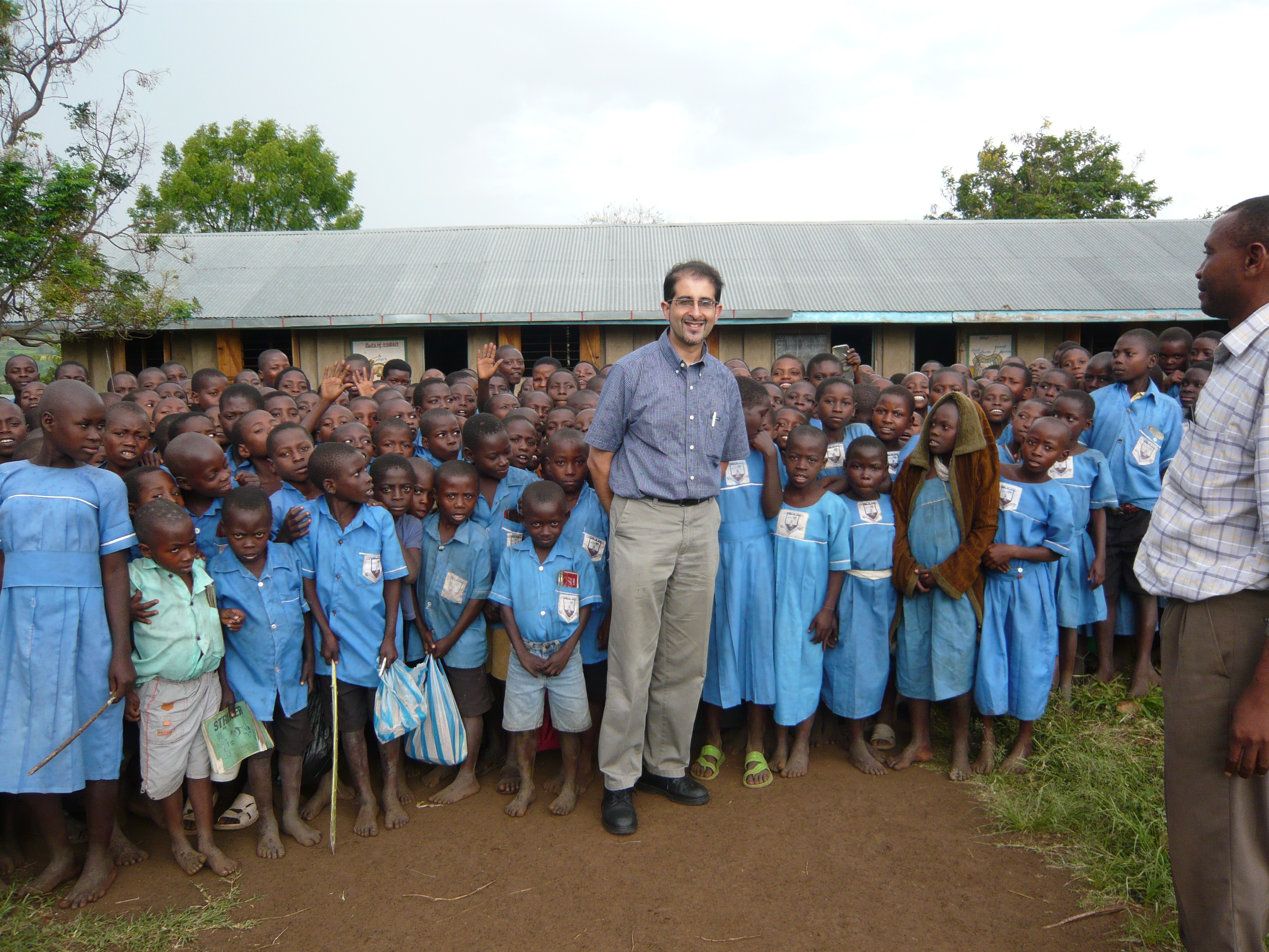 Arif Alibhai poses with local school children. Photo: Peter Rwakilembe