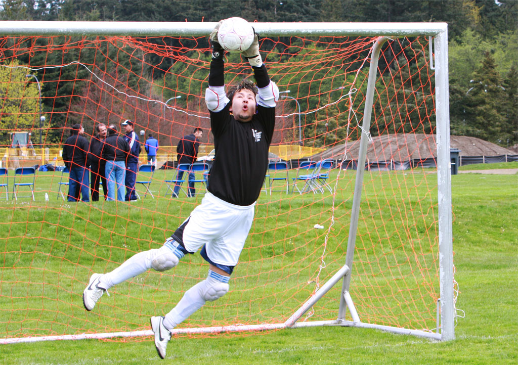 A soccer goalkeeper makes a save. Photo: Asif Bhalesha / Michelle Penny