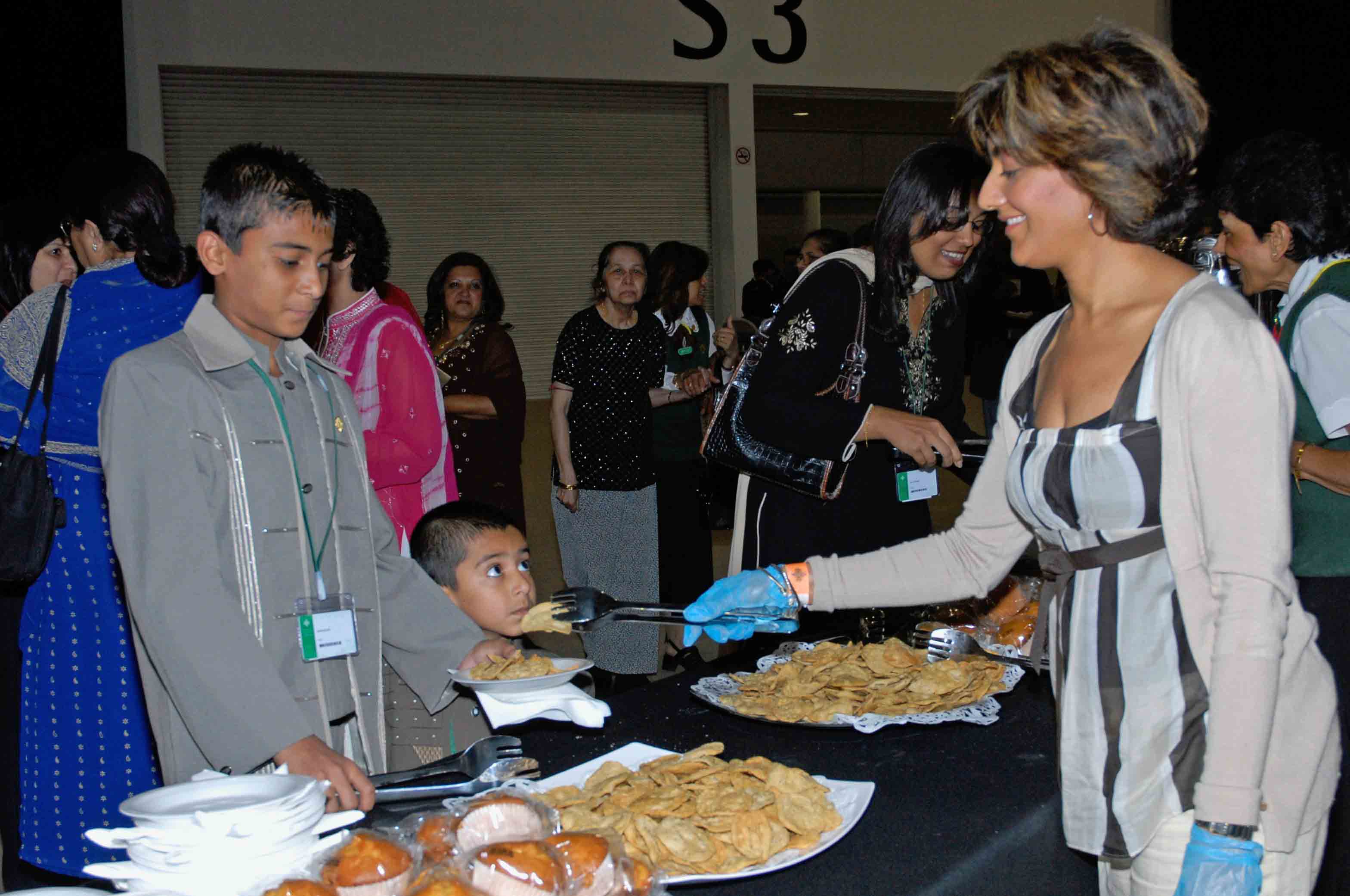 A volunteer smiles as she serves food at ExCeL London. Photo: Courtesy of the Ismaili Council for the UK