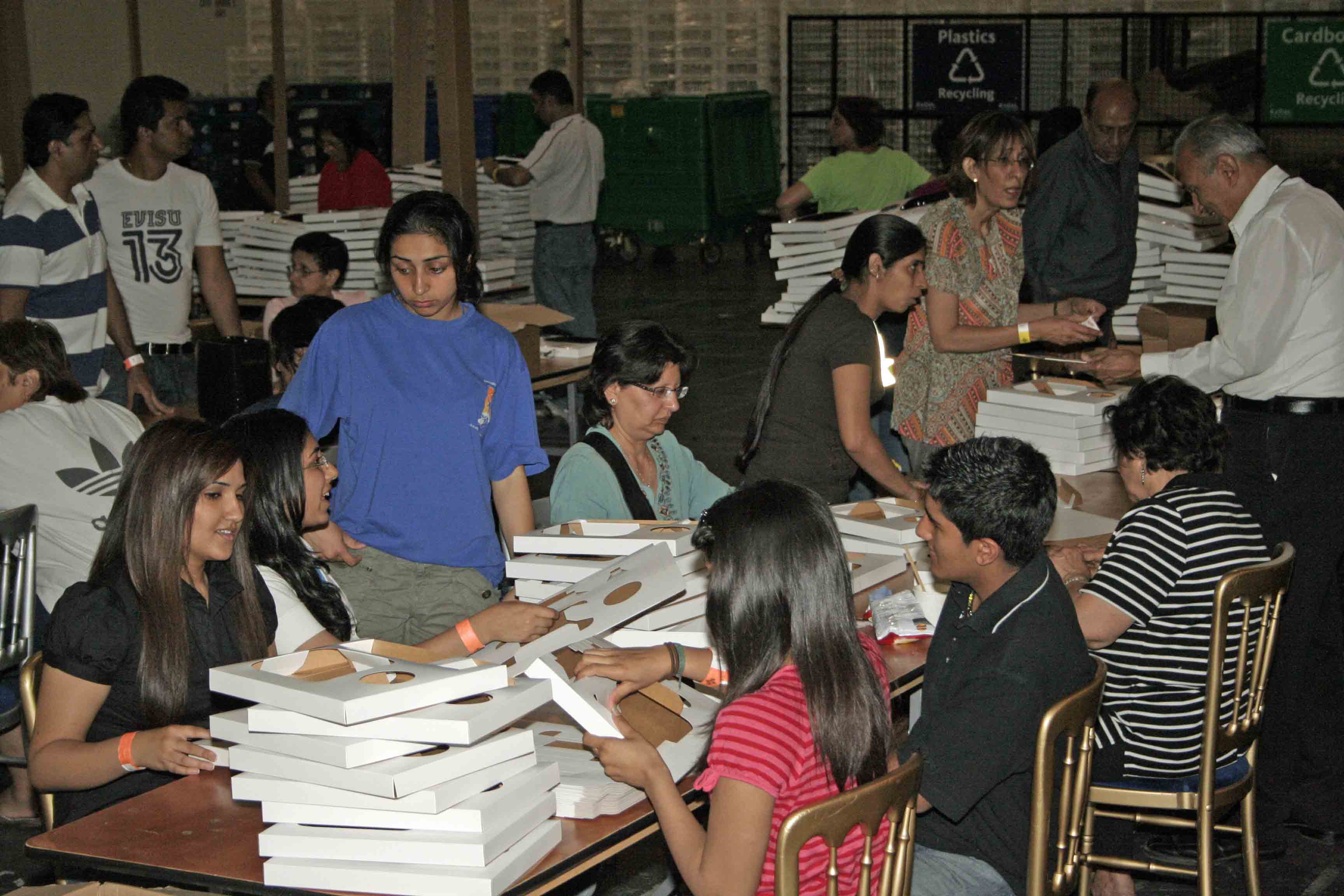 Volunteers prepare food trays for the Jamat during the visit. Photo: Courtesy of the Ismaili Council for the UK