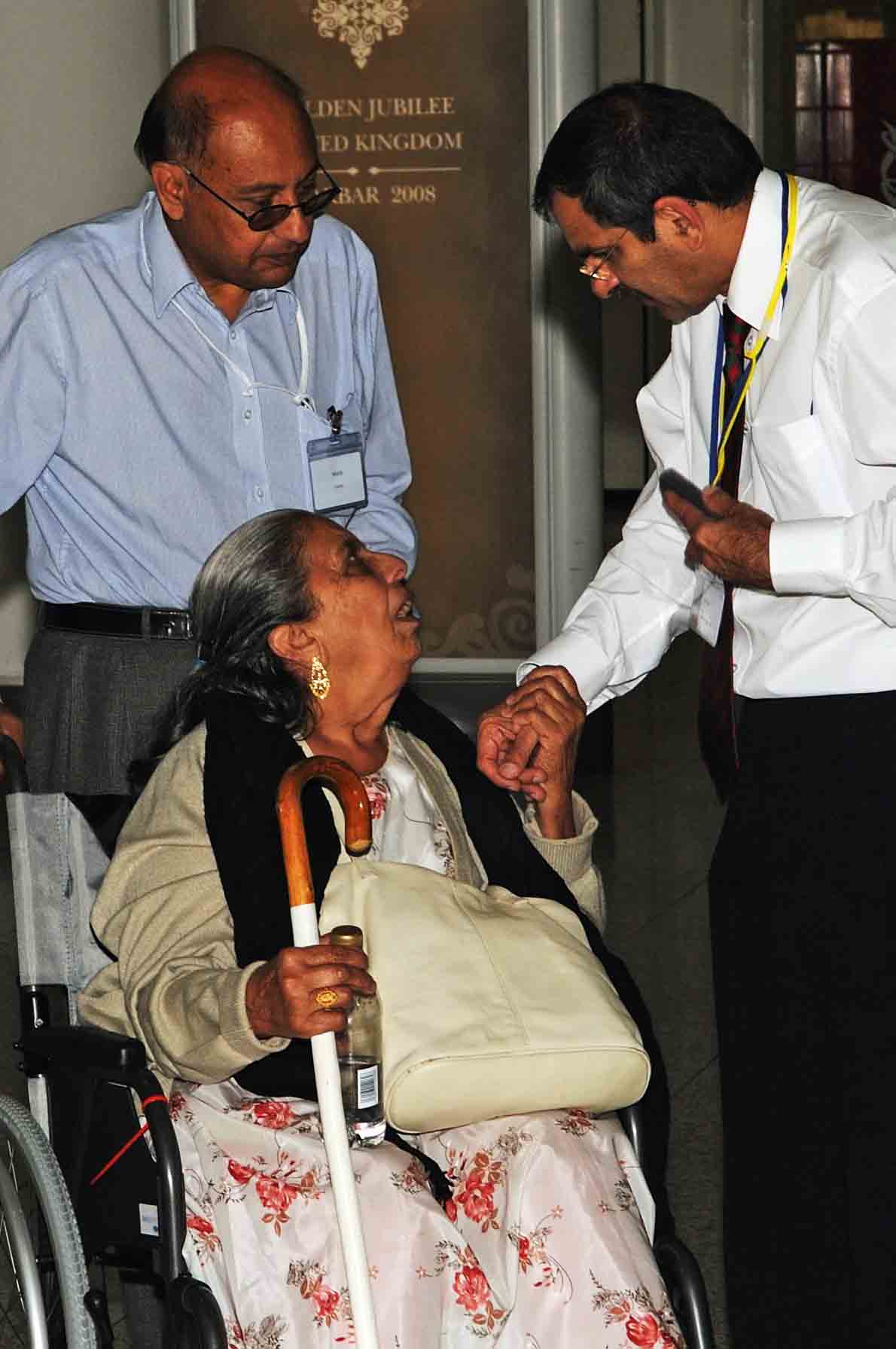 A volunteer welcomes an elderly member of the Jamat and offers assistance. Photo: Courtesy of the Ismaili Council for the UK