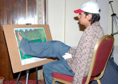 A regional winner from Islamabad who lost his forelimbs, sketches with his feet during the final event. Photo: Courtesy of ITREB Pakistan