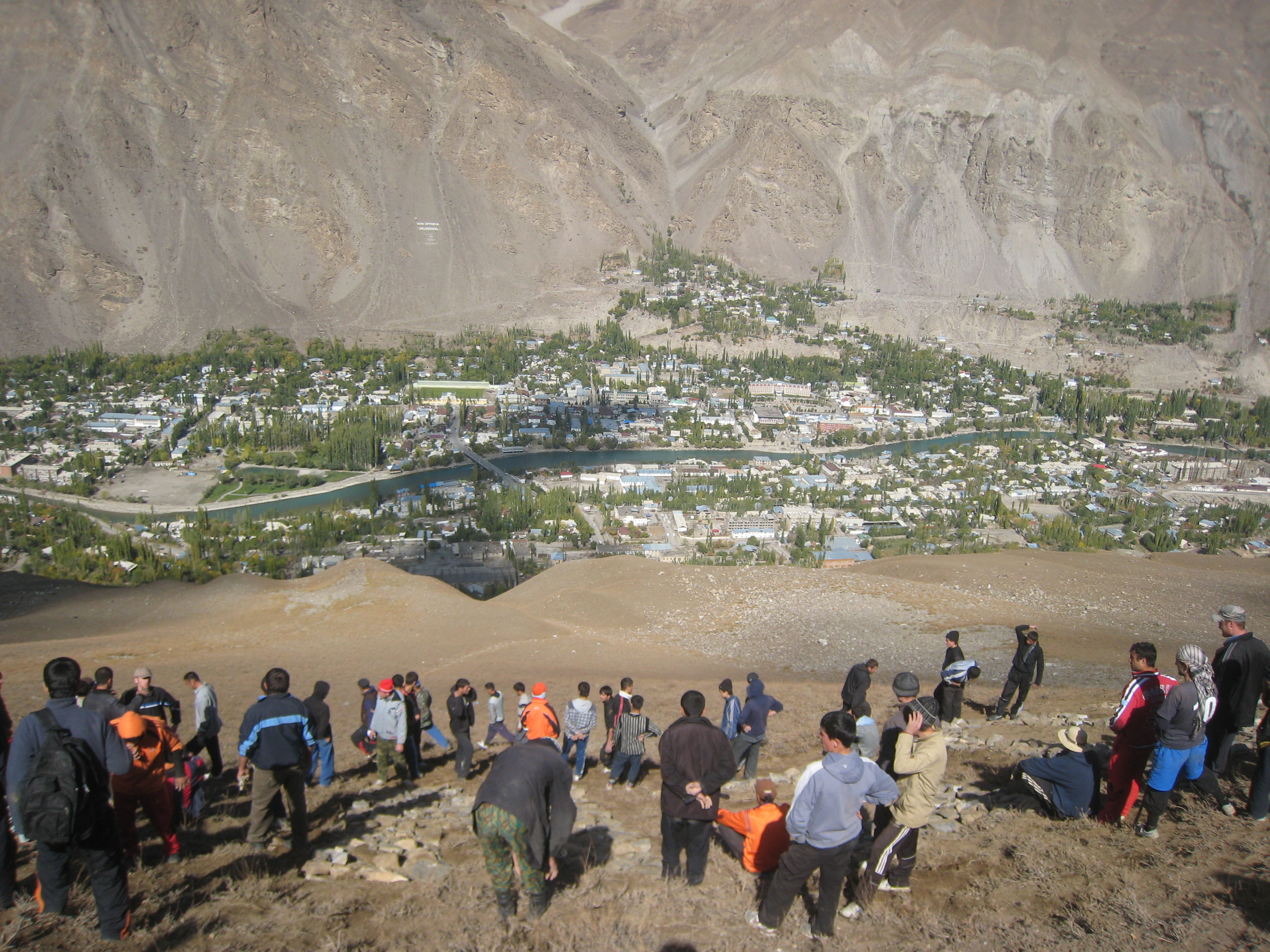 Volunteers move rocks to create a mountain-side Golden Jubilee welcome sign for Mawlana Hazar Imam. The city of Khorog is visible below. Photo: Gordon Cumming