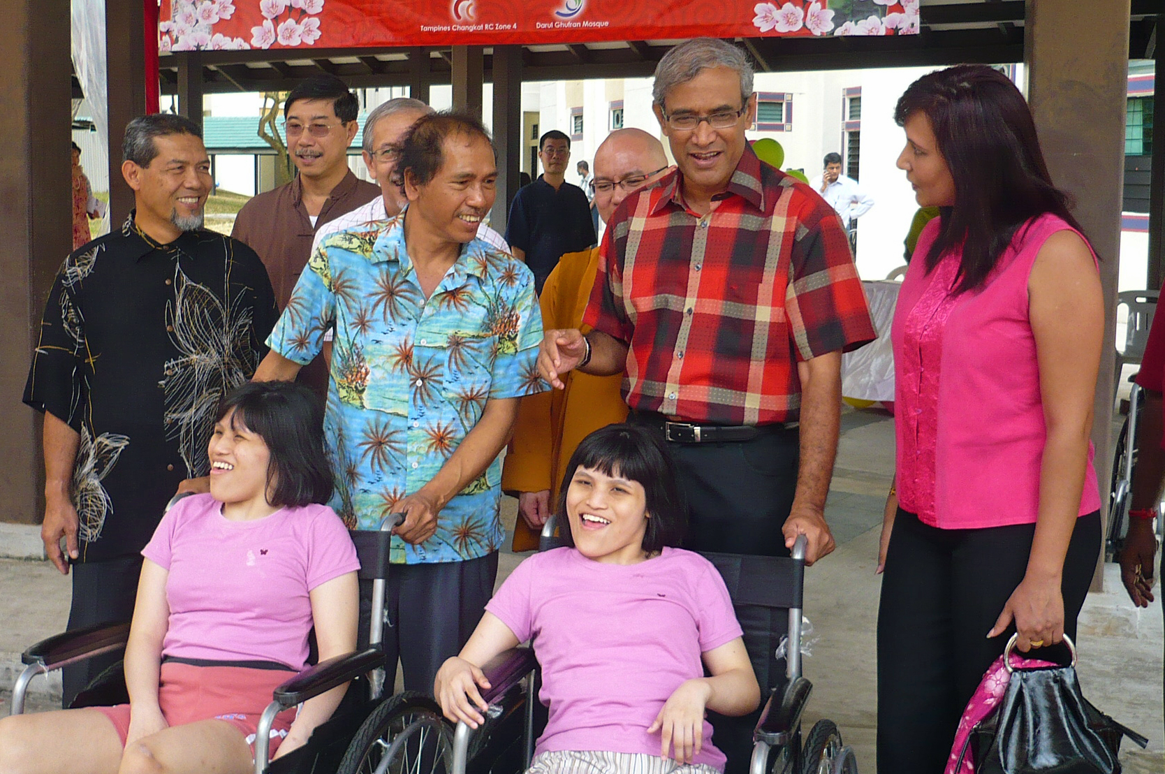 Senior Minister of State for Foreign Affairs and Mayor of North East CDC, Zainul Abidin Rasheed and Presidentbanoo Karam Bana in a conversation with Mr Osman bin Ahmad, whose twin daughters received wheelchairs. Photo: Haneesa Habib