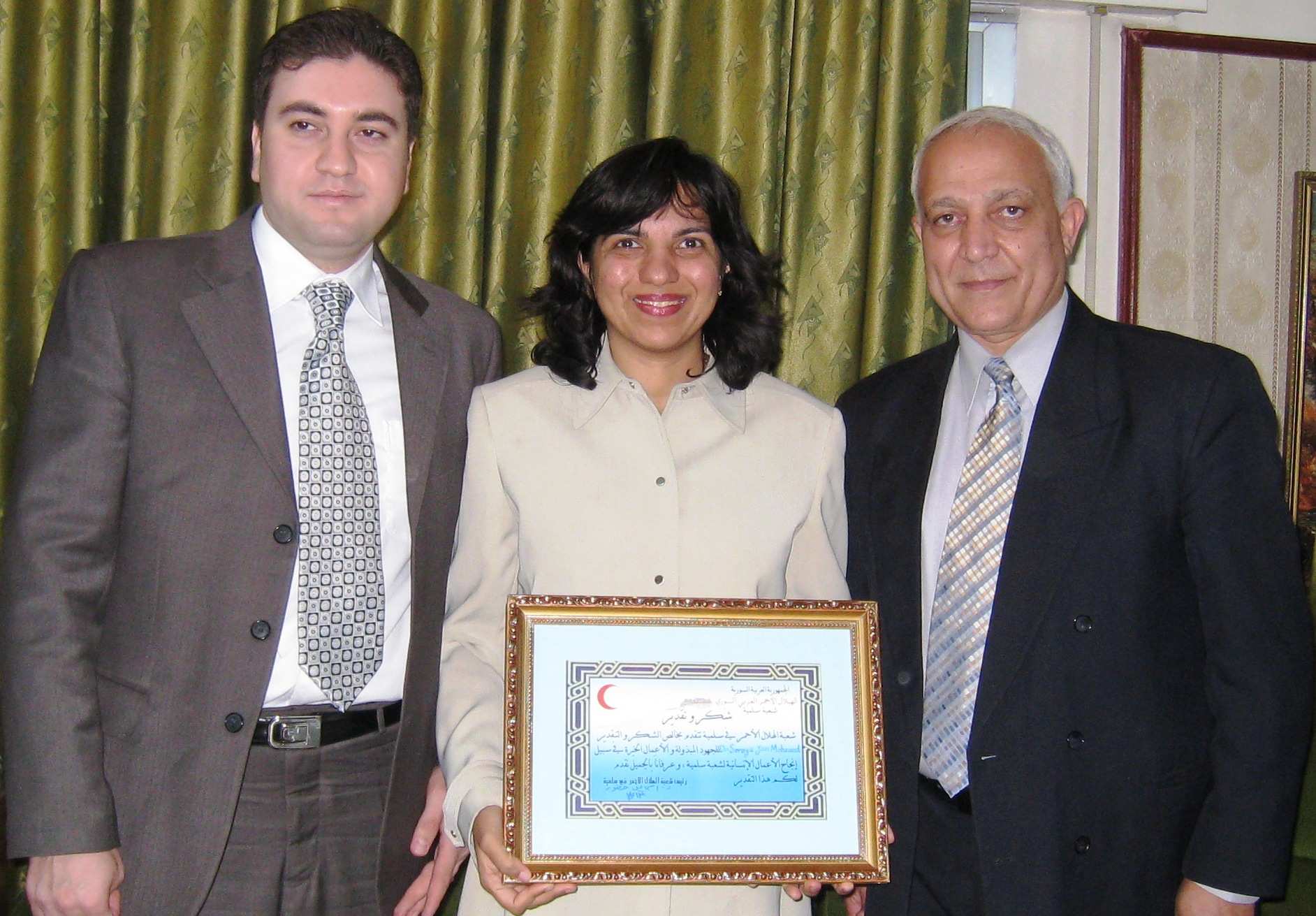 Dr Janmohamed and Dr Alhamwi receive a humanitarian award from a representative of the Syrian Red Crescent. Photo: Zahir Daya