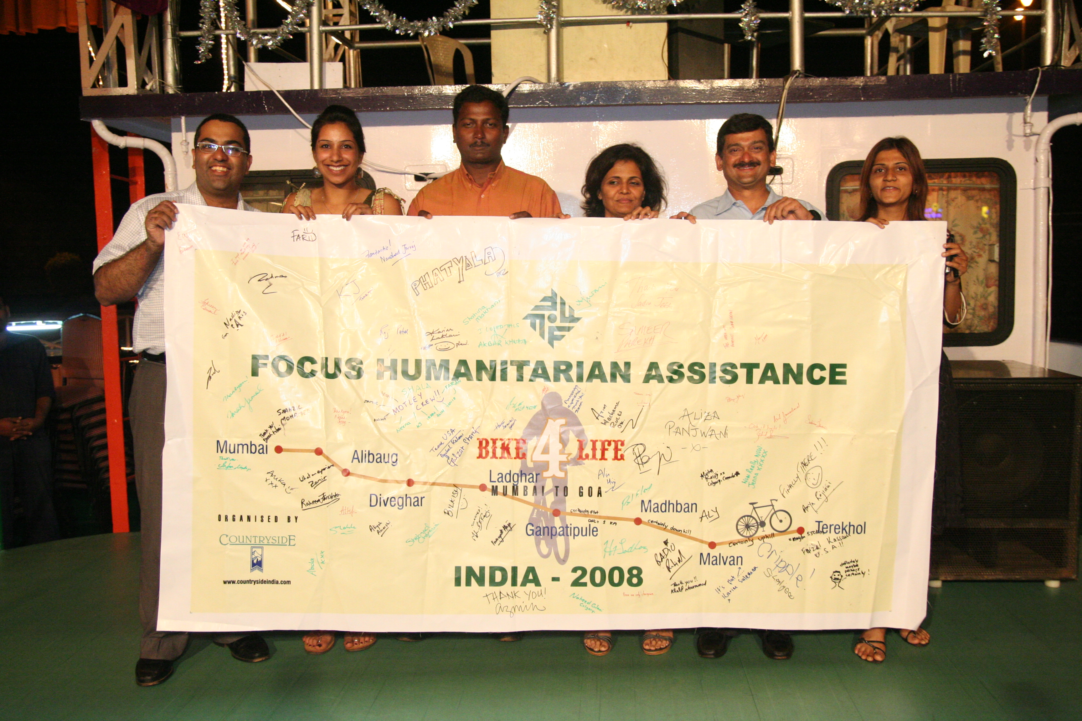 At the farewell dinner held on a boat off the coast of Goa, organisers from FOCUS, together with Countryside India, the tour company for the event, hold up a banner detailing the route, which has been signed by the entire group. Photo: Shahla Sunderji