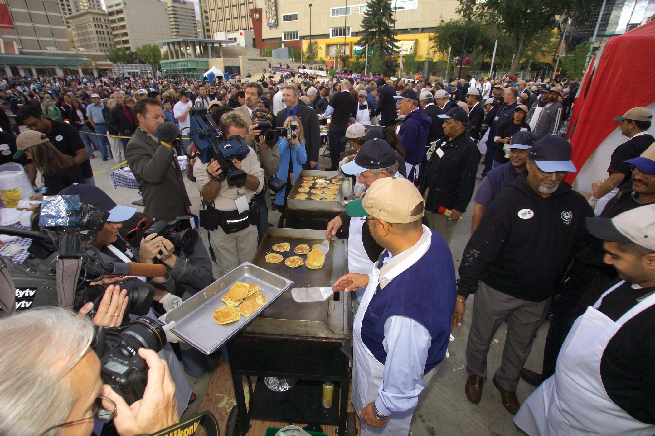 Former Alberta Premier Ralph Klein and President Nizar Somji of the Ismaili Council for Edmonton get ready to flip a few pancakes to mark Alberta's 100th birthday and the City of Edmonton's first ever pancake breakfast. Photo: (Firozali) Phil Musani