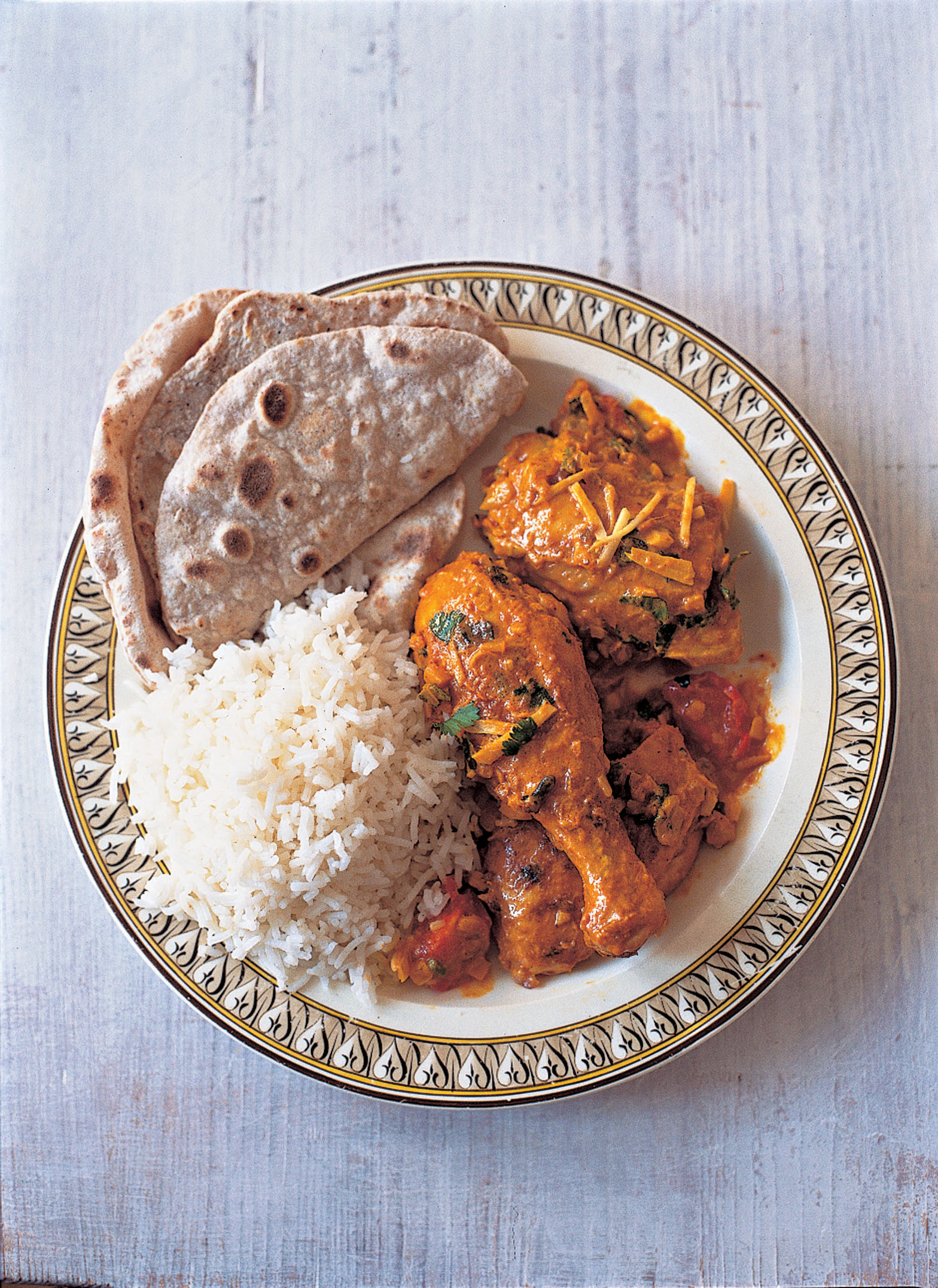 Half the plate is filled with chicken curry, the other half with rice and chapatis. Photo: Courtesy of Azmina Govindji