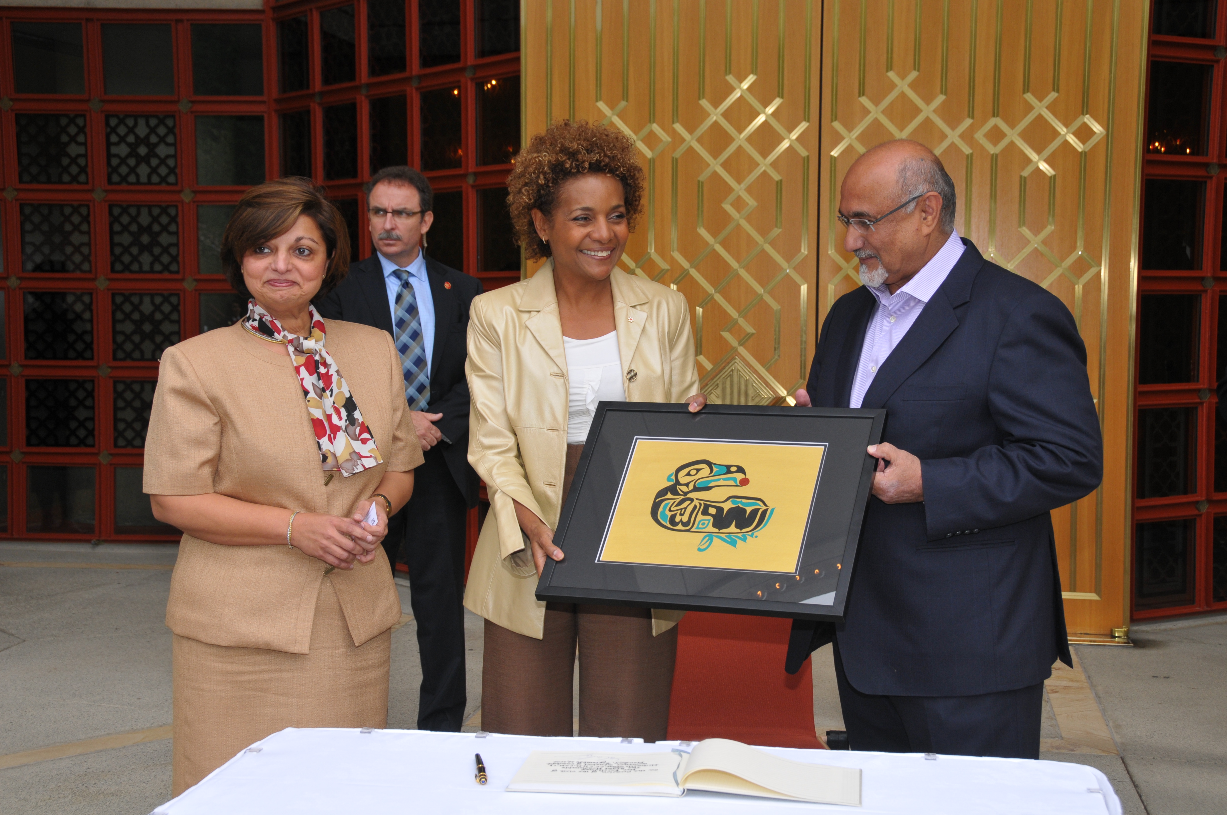 Following an Olympic Truce dialogue hosted at the Ismaili Centre, Burnaby, Presidents Mohamed Manji and Samira Alibhai, of the Ismaili Councils for Canada and British Columbia, present a gift – the Bismillah Raven by Sherazad Jamal – to the Governor General. The gift represents a multiplicity of expressions and the coming together of two cultures. Photo: Aziz Ladha