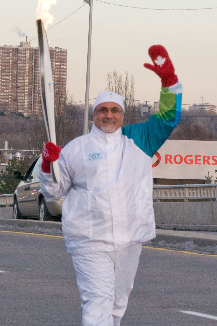 President Manji waves at the residents of Don Mills as he carries the Olympic Torch along York Mills Road in Toronto. Photo: Moez Visram